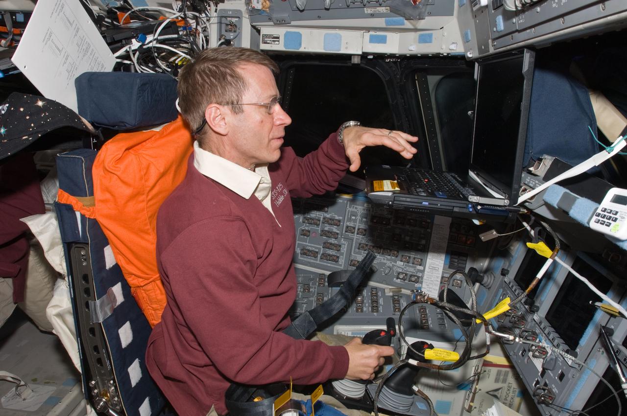 S125-E-013040 (21 May 2009) --- Occupying the commander?s station, astronaut Gregory C. Johnson, STS-125 pilot, uses the Portable In-Flight Landing Operations Trainer (PILOT) on the flight deck of the Earth-orbiting Space Shuttle Atlantis. PILOT consists of a laptop computer and a joystick system, which helps to maintain a high level of proficiency for the end-of-mission approach and landing tasks required to bring the shuttle safely back to Earth.