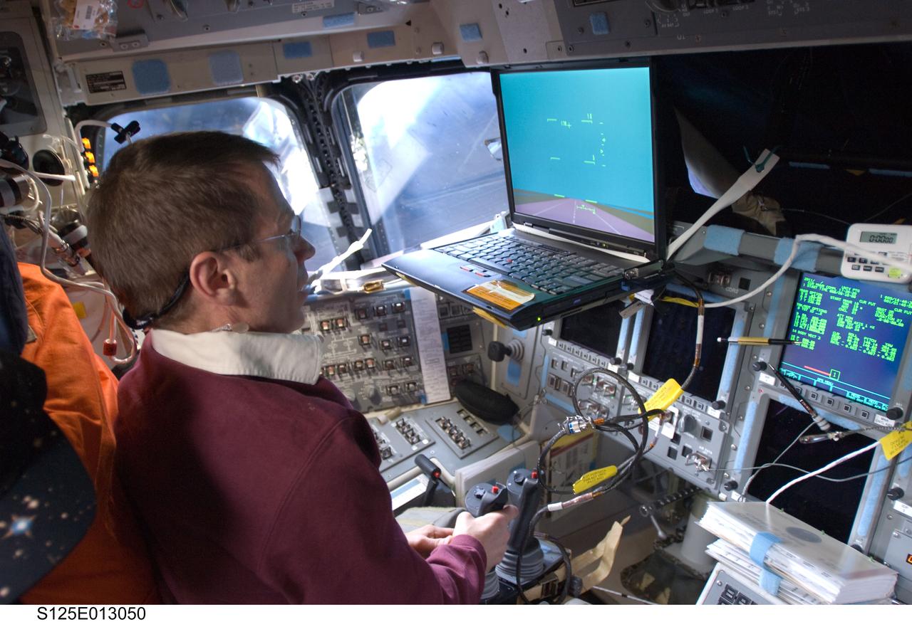 S125-E-013050 (21 May 2009) --- Occupying the commander?s station, astronaut Gregory C. Johnson, STS-125 pilot, uses the Portable In-Flight Landing Operations Trainer (PILOT) on the flight deck of the Earth-orbiting Space Shuttle Atlantis. PILOT consists of a laptop computer and a joystick system, which helps to maintain a high level of proficiency for the end-of-mission approach and landing tasks required to bring the shuttle safely back to Earth.