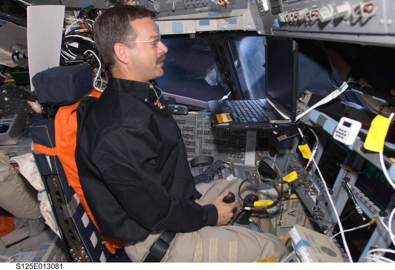 S125-E-013081 (21 May 2009) --- Occupying the commander?s station, astronaut Scott Altman, STS-125 commander, uses the Portable In-Flight Landing Operations Trainer (PILOT) on the flight deck of the Earth-orbiting Space Shuttle Atlantis. PILOT consists of a laptop computer and a joystick system, which helps to maintain a high level of proficiency for the end-of-mission approach and landing tasks required to bring the shuttle safely back to Earth.