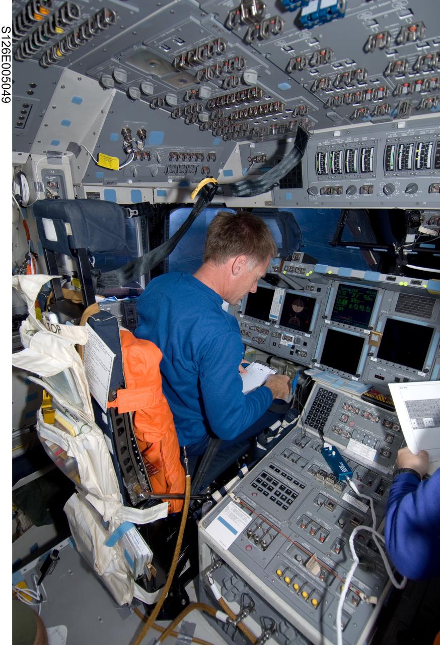 S126-E-005049 (14 Nov. 2008) --- Astronaut Chris Ferguson, STS-126 commander, looks over a checklist while occupying the commander's station on the flight deck of Space Shuttle Endeavour during post launch activities.