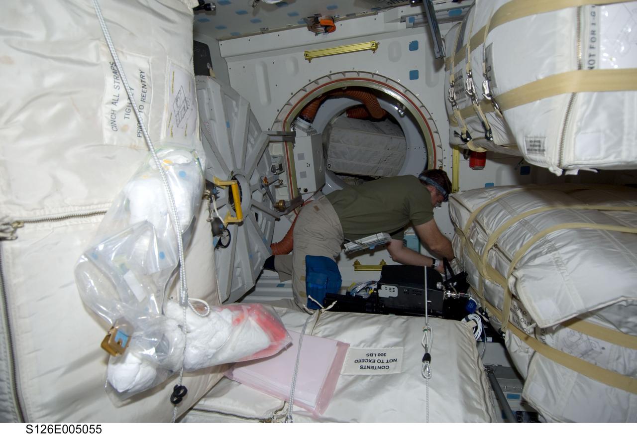 S126-E-005055 (14 Nov. 2008) --- Astronaut Steve Bowen, STS-126 mission specialist, works among stowage bags on the middeck of the Space Shuttle Endeavour during post launch activities.