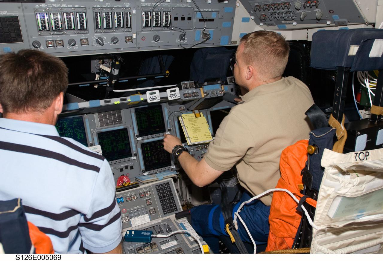S126-E-005069 (15 Nov. 2008) --- On Endeavour's forward flight deck, astronauts Chris Ferguson (left), STS-126 commander, and Eric Boe, pilot, prepare for the following day's scheduled rendezvous and docking with the International Space Station.