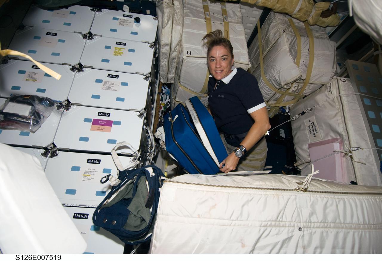 S126-E-007519 (15 Nov. 2008) --- Astronaut Heidemarie Stefanyshyn-Piper, STS-126 mission specialist, works among stowage bags on the middeck of Space Shuttle Endeavour during flight day two activities.