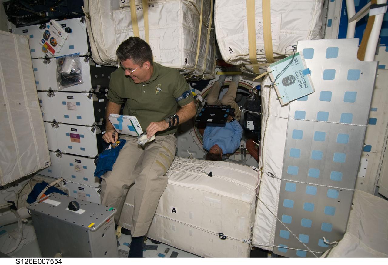 S126-E-007554 (15 Nov. 2008) --- Astronaut Steve Bowen, STS-126 mission specialist, is pictured on the middeck of Space Shuttle Endeavour during flight day two activities. Astronaut Sandra Magnus, mission specialist, is visible in the background.