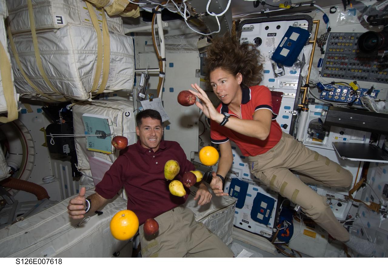 S126-E-007618 (16 Nov. 2008) --- Astronauts Shane Kimbrough and Sandra Magnus, both STS-126 mission specialists, are pictured with fresh fruit floating freely on the middeck of Space Shuttle Endeavour during flight day three activities.