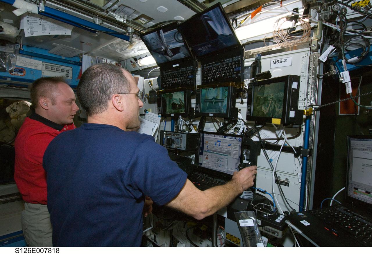 S126-E-007818 (16 Nov. 2008) --- Astronauts Donald Pettit (foreground), STS-126 mission specialist, and Michael Fincke, Expedition 18 commander, work the controls of the station's robotic Canadarm2 in the Destiny laboratory of the International Space Station while Space Shuttle Endeavour is docked with the station.