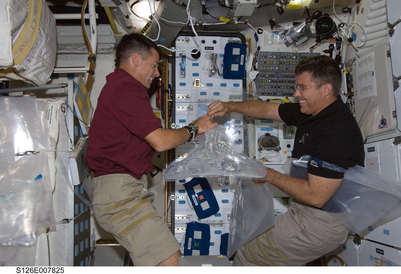 S126-E-007825 (16 Nov. 2008) --- Astronauts Shane Kimbrough (left) and Steve Bowen, both STS-126 mission specialists, work on the middeck of Space Shuttle Endeavour during flight day three activities.