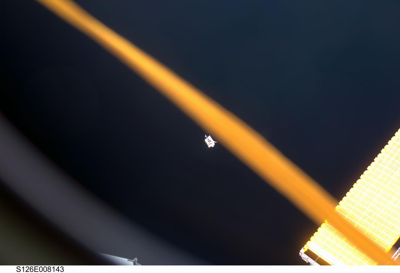 S126-E-008143 (18 Nov. 2008) --- An extravehicular activity (EVA) tool bag drifts away from the International Space Station during the mission's first scheduled spacewalk for STS-126. About halfway into the spacewalk, one of the grease guns that astronaut Heidemarie Stefanyshyn-Piper (out of frame), mission specialist, was preparing to use on the Solar Alpha Rotary Joint released some Braycote grease into her crew lock bag, which is the tool bag the spacewalkers use during their activities. As she was cleaning the inside of the bag, it drifted away from her and toward the aft and starboard portion of the International Space Station. Inside the bag were two grease guns, a scraper, a scraper debris container, several wipes in a caddy and tethers.