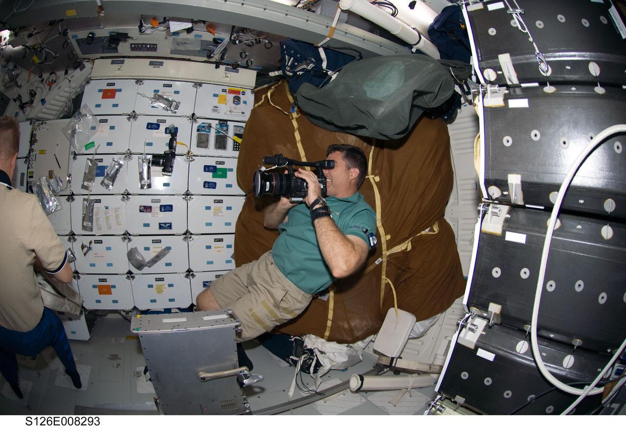 S126-E-008293 (19 Nov. 2008) --- Astronaut Steve Bowen, STS-126 mission specialist, uses a video camera on the middeck of Space Shuttle Endeavour while docked with the International Space Station.