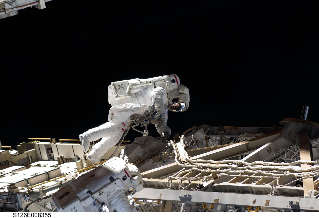 S126-E-008355 (20 Nov. 2008) --- Astronauts Heidemarie Stefanyshyn-Piper (top) and Shane Kimbrough, both STS-126 mission specialists, participate in the mission's second scheduled session of extravehicular activity (EVA) as construction and maintenance continue on the International Space Station. During the six-hour, 45-minute spacewalk, Piper and Kimbrough continued the process of removing debris and applying lubrication around the starboard Solar Alpha Rotary Joint (SARJ), replaced four more of the SARJ's 12 trundle bearing assemblies, relocated two equipment carts and applied lubrication to the station's robotic Canadarm2.