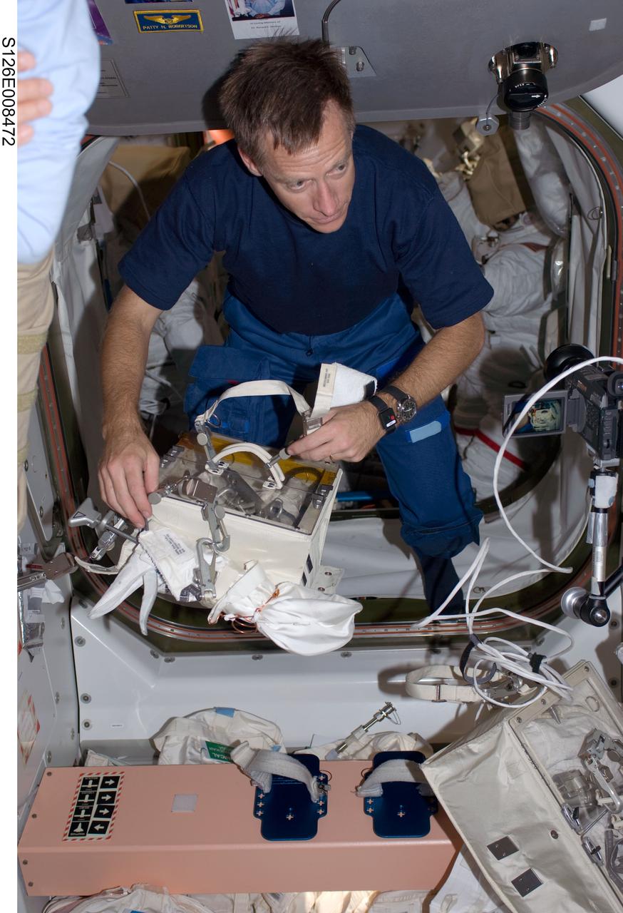 S126-E-008472 (19 Nov. 2008) --- Astronaut Chris Ferguson, STS-126 commander, holds a crew lock bag which contains extravehicular activity (EVA) tools in the Unity node of the International Space Station while Space Shuttle Endeavour remains docked with the station.