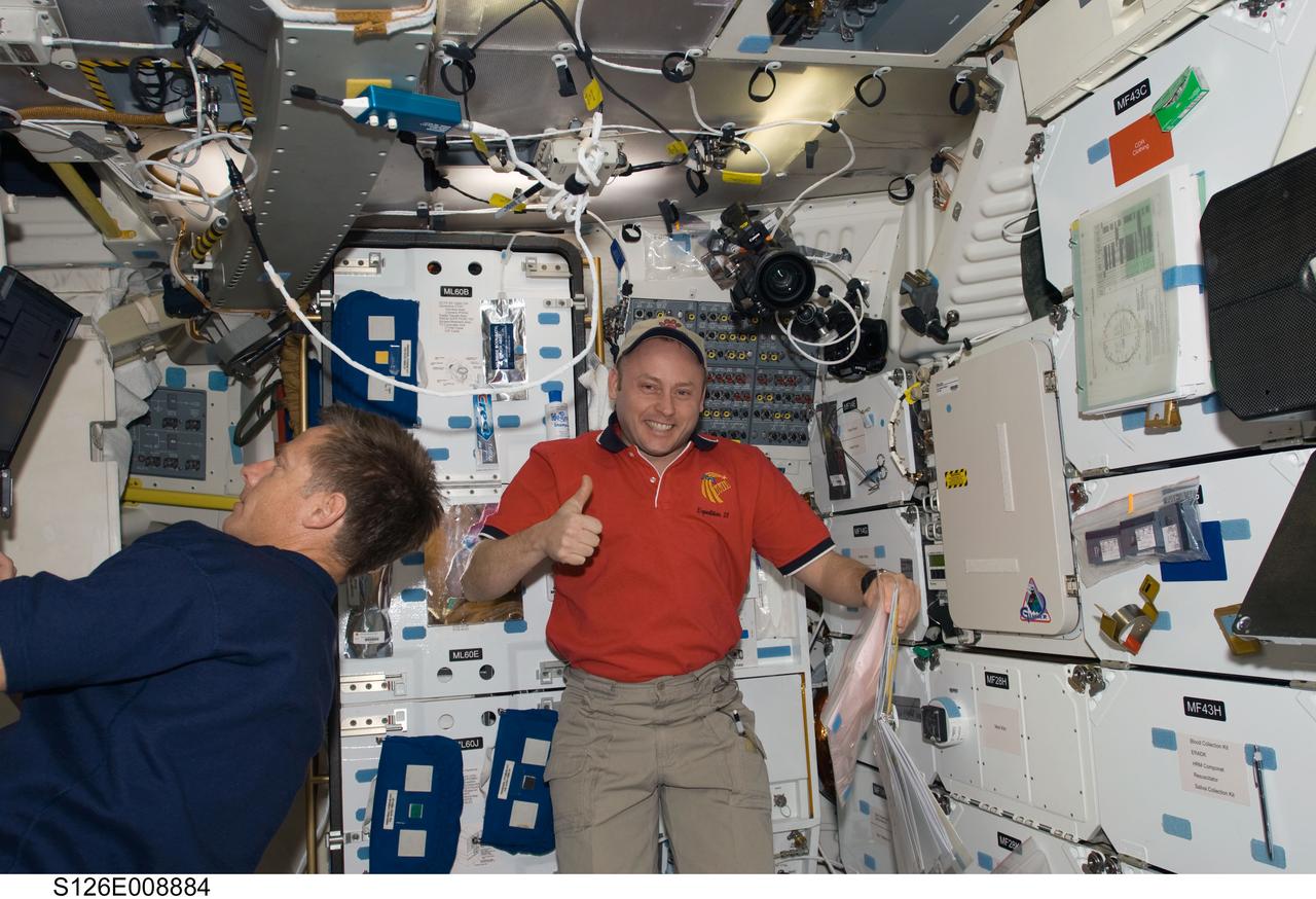 S126-E-008884 (21 Nov. 2008) --- This image, recorded in the late evening hours of Nov. 21, Houston time,  shows astronaut Michael Fincke, Expedition 18 commander, joining his Endeavour counterpart, astronaut Chris Ferguson, on the mid deck of the space shuttle.  The photo may cause observers to do a double take; though  Fincke's recently having begun his second tour aboard the International Space Station, the environs of the shuttle are not so familiar to him as those of the station.  Members of the respective crews commanded by Ferguson and Fincke are spending close to two weeks in space together, accomplishing home improvement chores and a number of other tasks. Just a few hours after this photo was taken, two astronauts started prepping for the joint crews' third spacewalk of the week.