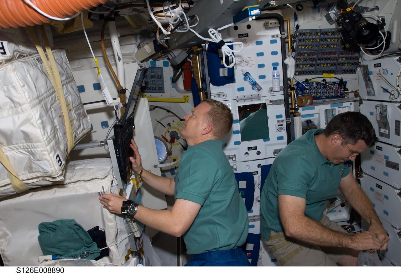 S126-E-008890 (21 Nov. 2008) --- This image, recorded in the late evening hours of Nov. 21, Houston time, shows astronauts Eric Boe, left, and Steve Bowen on the mid deck of the Space Shuttle Endeavour. Just a few hours after this photo was taken, Bowen was one of two astronauts who started prepping for the joint crews' third spacewalk (and Bowen's second) of the week. Members of the shuttle and station crews, commanded by astronauts Chris Ferguson and Michael Fincke, respectively, are spending close to two weeks in space together, accomplishing home improvement chores and a number of other tasks.