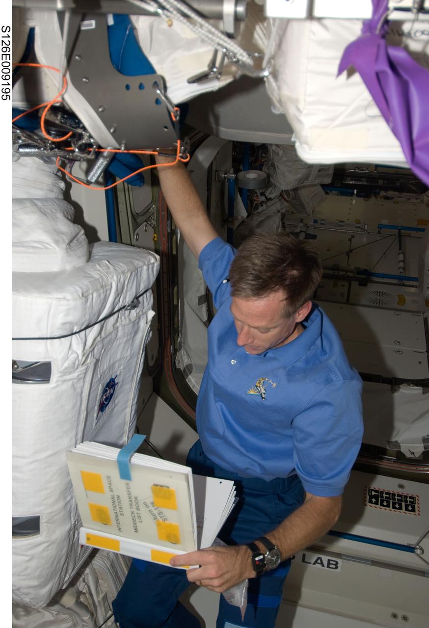 S126-E-009195 (23 Nov. 2008) --- Astronaut Chris Ferguson, STS-126 commander, looks over a checklist in the Unity node of the International Space Station while Space Shuttle Endeavour remains docked with the station.