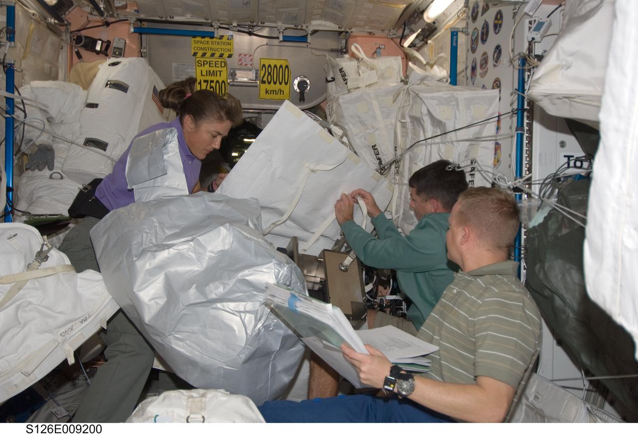 S126-E-009200 (23 Nov. 2008) --- Astronauts Eric Boe (right foreground), STS-126 pilot; Shane Kimbrough and Heidemarie Stefanyshyn-Piper, both mission specialists, work in the Unity node of the International Space Station while Space Shuttle Endeavour remains docked with the station.