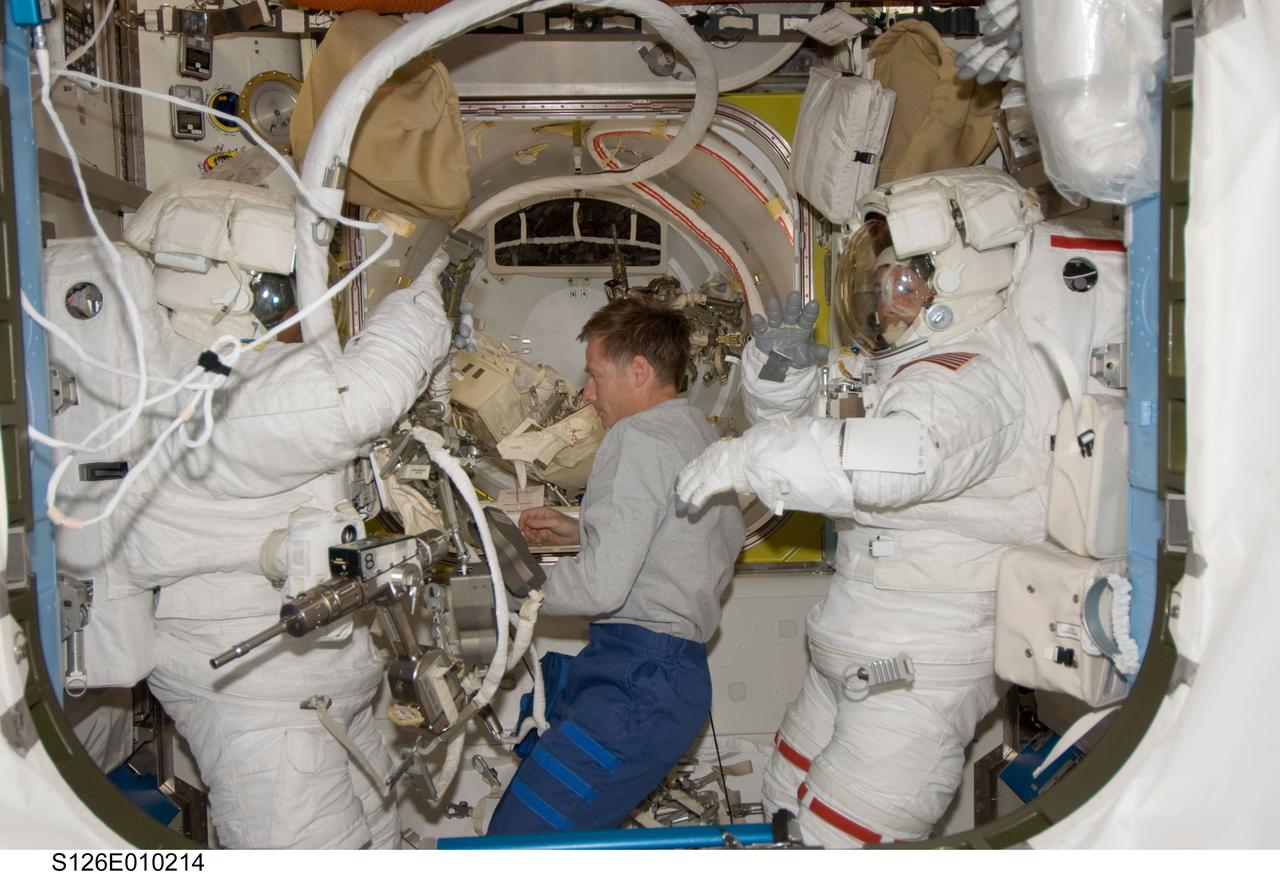 S126-E-010214 (24 Nov. 2008) --- Astronauts Steve Bowen (left) and Shane Kimbrough, both STS-126 mission specialists, attired in their Extravehicular Mobility Unit (EMU) spacesuits, prepare for the mission's fourth and final session of extravehicular activity (EVA) in the Quest Airlock of the International Space Station while Space Shuttle Endeavour remains docked with the station. Astronaut Chris Ferguson, commander, assists Bowen and Kimbrough.