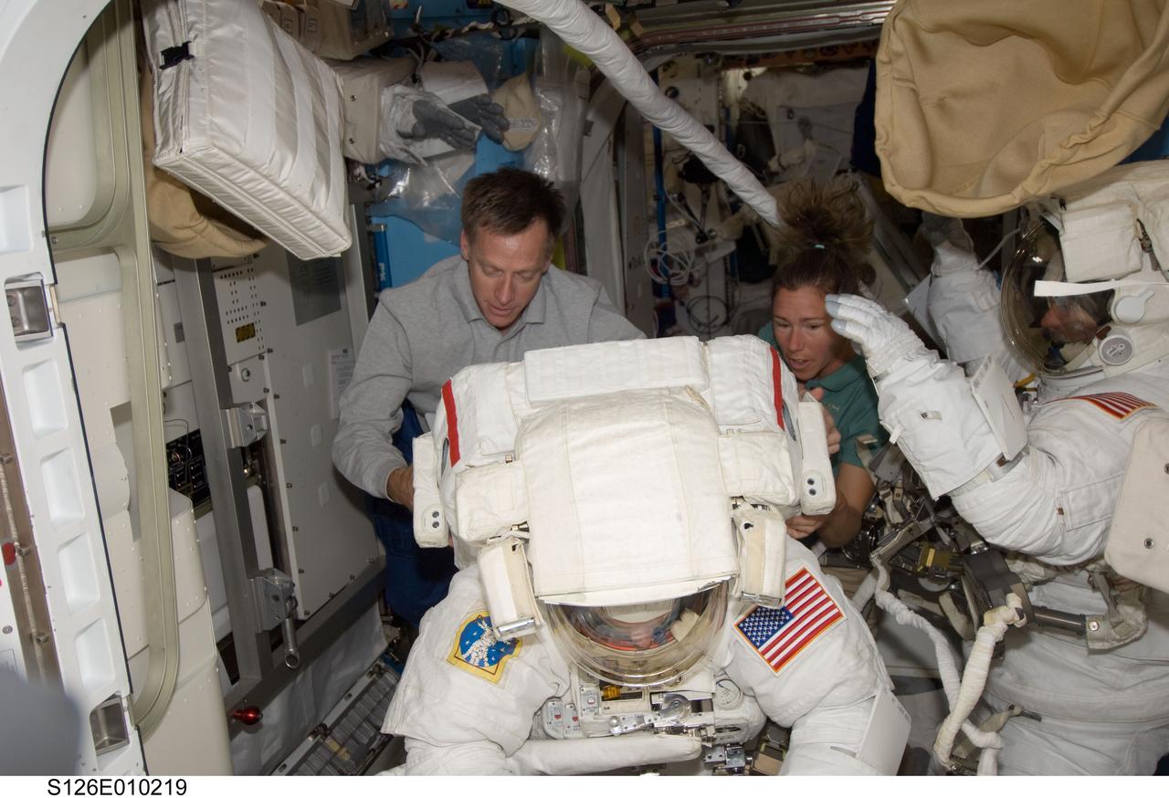 S126-E-010219 (24 Nov. 2008) --- Astronauts Shane Kimbrough (foreground) and Steve Bowen, both STS-126 mission specialists, attired in their Extravehicular Mobility Unit (EMU) spacesuits, prepare for the mission's fourth and final session of extravehicular activity (EVA) in the Quest Airlock of the International Space Station while Space Shuttle Endeavour remains docked with the station. Astronauts Chris Ferguson, commander, and Sandra Magnus, Expedition 18 flight engineer, assist Bowen and Kimbrough.