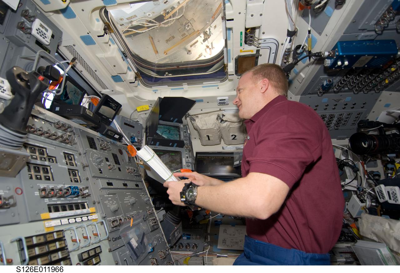 S126-E-011966 (26 Nov. 2008) --- Astronaut Eric Boe, STS-126 pilot, looks over a procedures manual on the aft flight deck of the Space Shuttle Endeavour, scheduled to undock from the International Space Station later in the week.