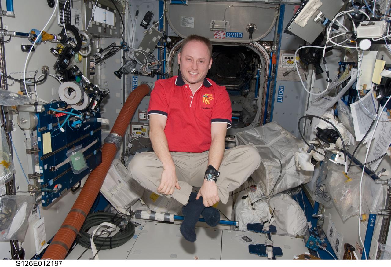 S126-E-012197 (27 Nov. 2008) --- It appears astronaut Michael Fincke, Expedition 18 commander, may be practicing his seating for an upcoming Thanksgiving meal. He had to leave this position in the Harmony or Node 2 of the International Space Station and traverse over to the Space Shuttle Endeavour for the meal, which he shared with two other station crew members and seven Endeavour astronauts.