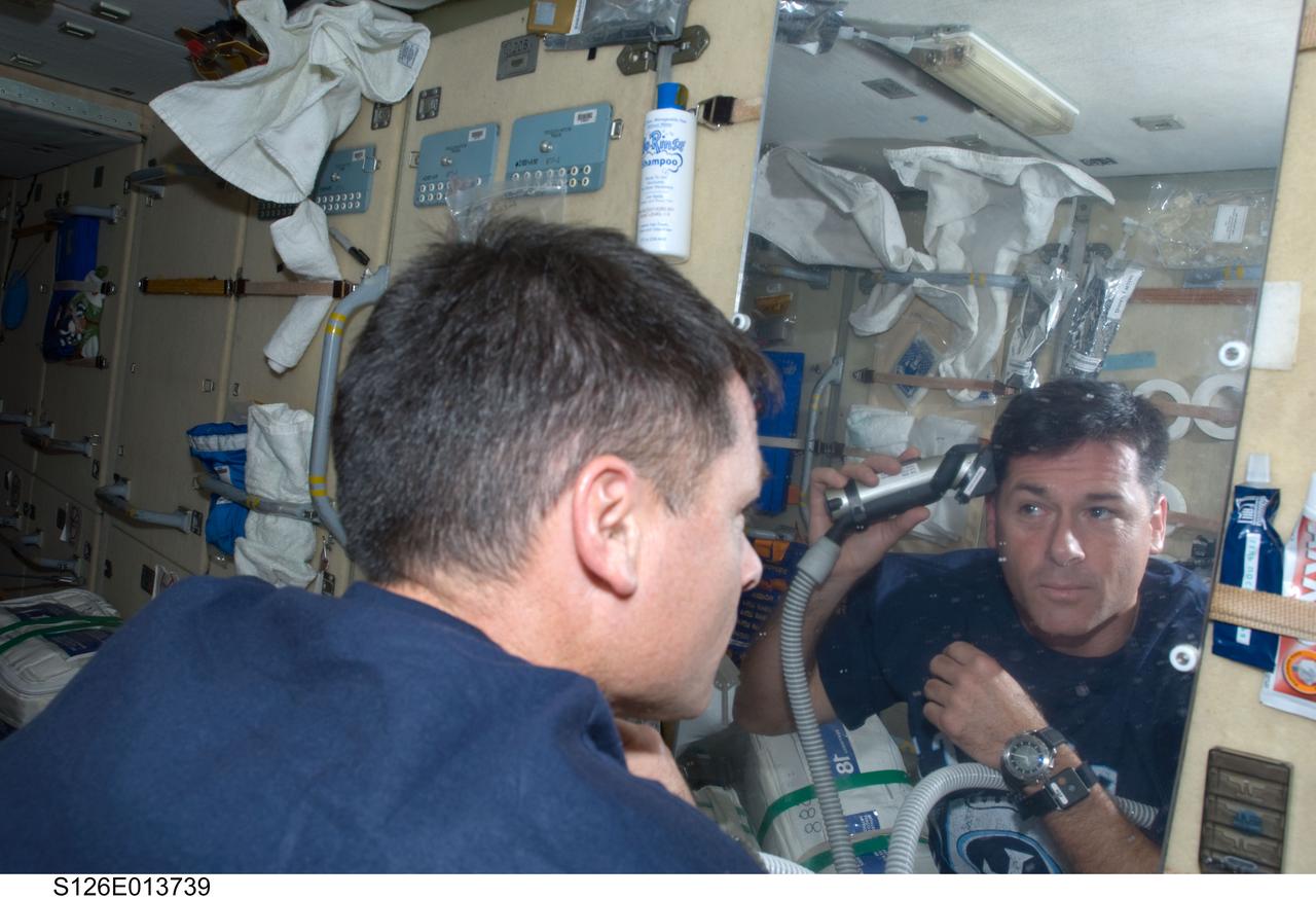 S126-E-013739 (27 Nov. 2008) --- Astronaut Shane Kimbrough, STS-126 mission specialist, gives himself a hair trim on the aft side of the Zarya functional cargo block aboard the International Space Station on Thanksgiving Day. One more day remains for the Space Shuttle Endeavour to be docked with the station.
