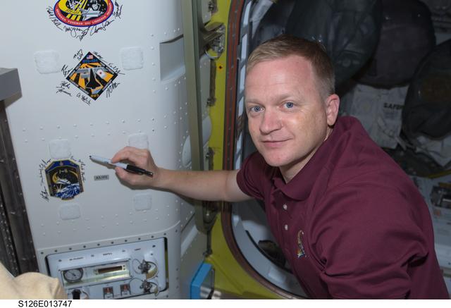 NASA image: Boe signs Mission Patch in A/L