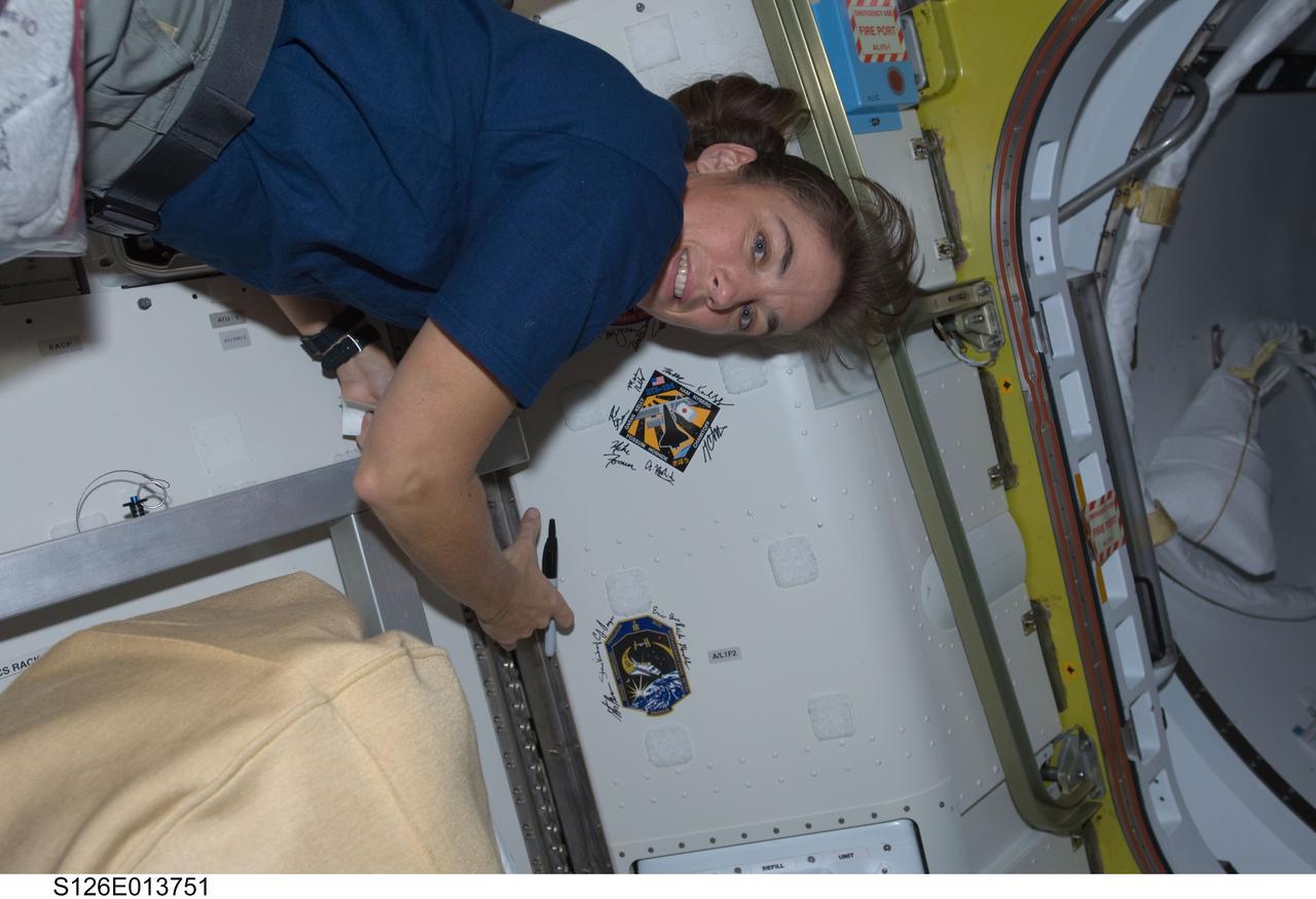 S126-E-013751 (27 Nov. 2008) --- Astronaut Heidemarie Stefanyshyn-Piper, STS-126 mission specialist, signs Endeavour's crew patch in the Quest Airlock of the International Space Station on Thanksgiving Day. One more day remains for the Space Shuttle Endeavour to be docked with the station.