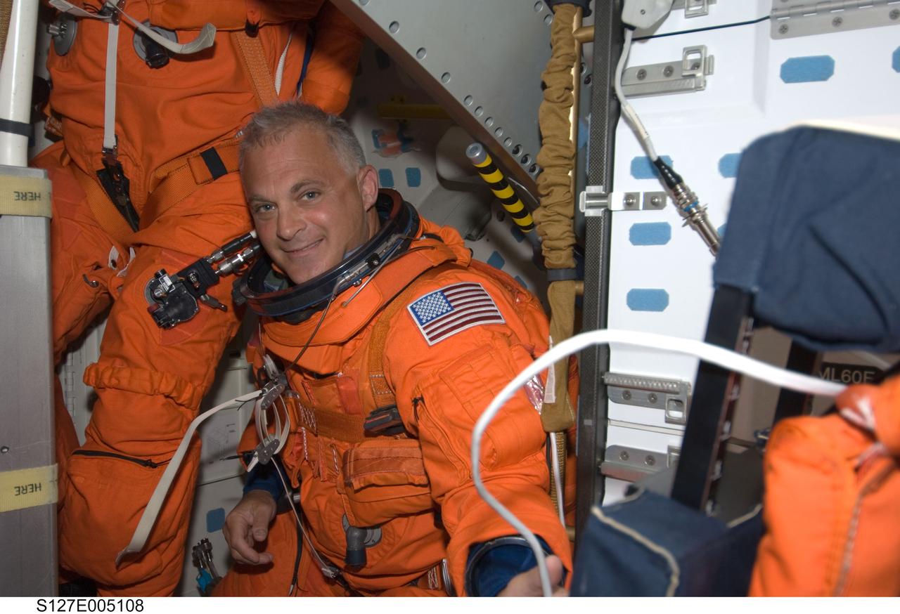 S127-E-005108 (15 July 2009) --- Astronaut Dave Wolf, STS-127 mission specialist, attired in his shuttle launch and entry suit, works on the middeck of Space Shuttle Endeavour during postlaunch activities.