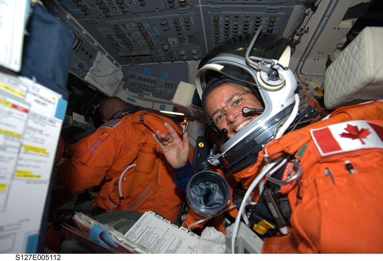 S127-E-005112 (15 July 2009) --- Canadian Space Agency astronaut Julie Payette, STS-127 mission specialist, attired in her shuttle launch and entry suit, takes a moment for a photo on the flight deck of Space Shuttle Endeavour during postlaunch activities. Astronaut Doug Hurley, pilot, is visible in the background.
