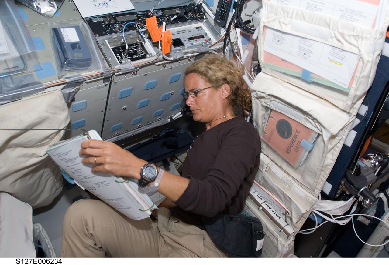 S127-E-006234 (16 July 2009) --- Canadian Space Agency astronaut Julie Payette, STS-127 mission specialist, reads a procedures checklist on the aft flight deck of Space Shuttle Endeavour during flight day two activities.