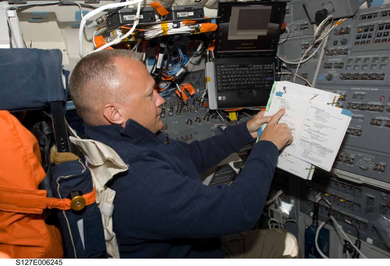 S127-E-006245 (16 July 2009) --- Astronaut Doug Hurley, STS-127 pilot, reads a procedures checklist on the aft flight deck of Space Shuttle Endeavour during flight day two activities.