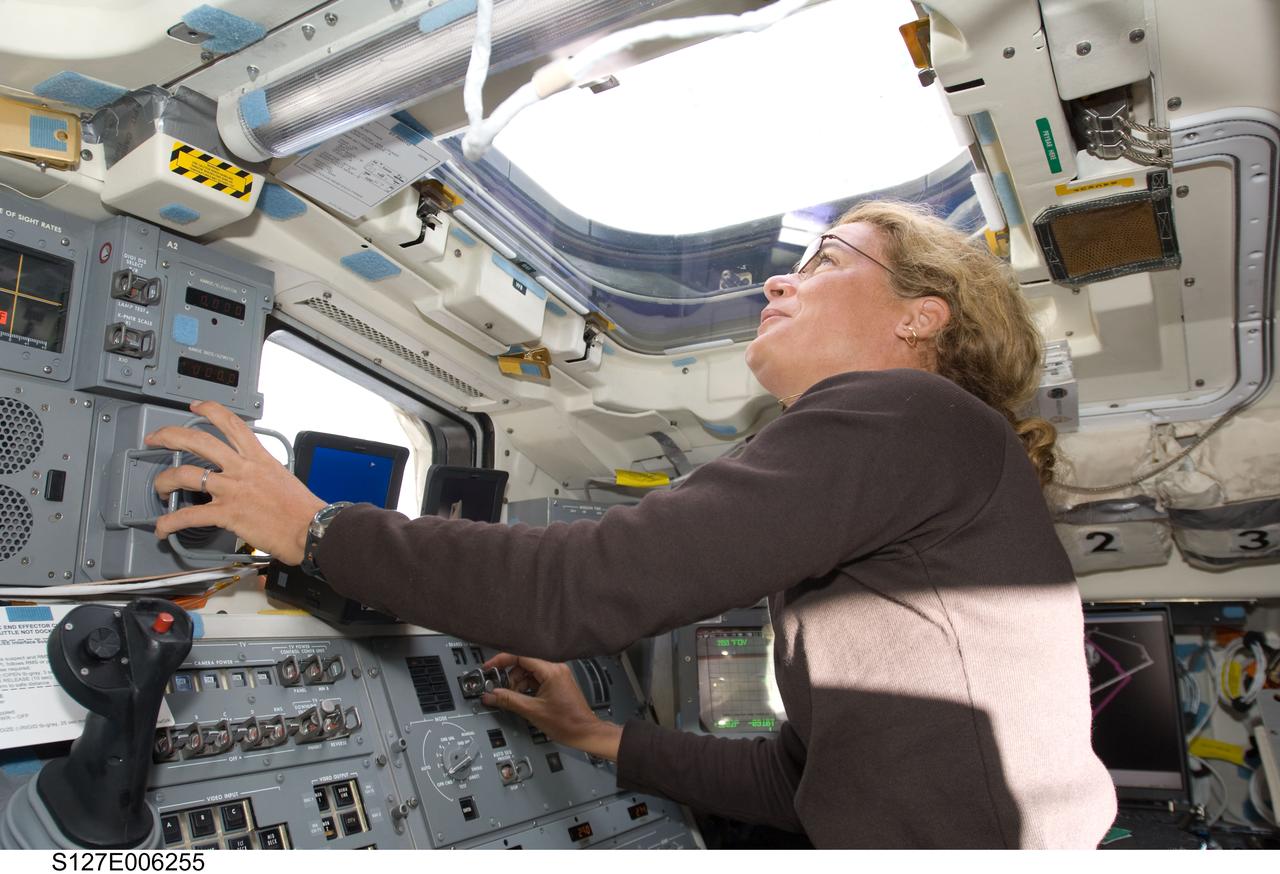 S127-E-006255 (16 July 2009) --- Canadian Space Agency astronaut Julie Payette, STS-127 mission specialist, looks through an overhead window while operating controls on the aft flight deck of Space Shuttle Endeavour during flight day two activities.