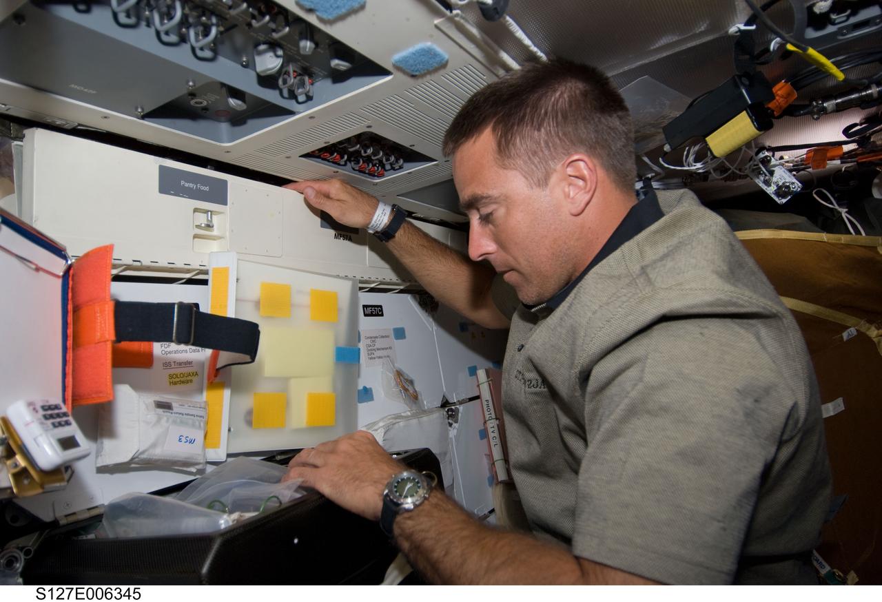 S127-E-006345 (16 July 2009) --- Astronaut Christopher Cassidy, STS-127 mission specialist, works on the middeck of Space Shuttle Endeavour during flight day two activities.