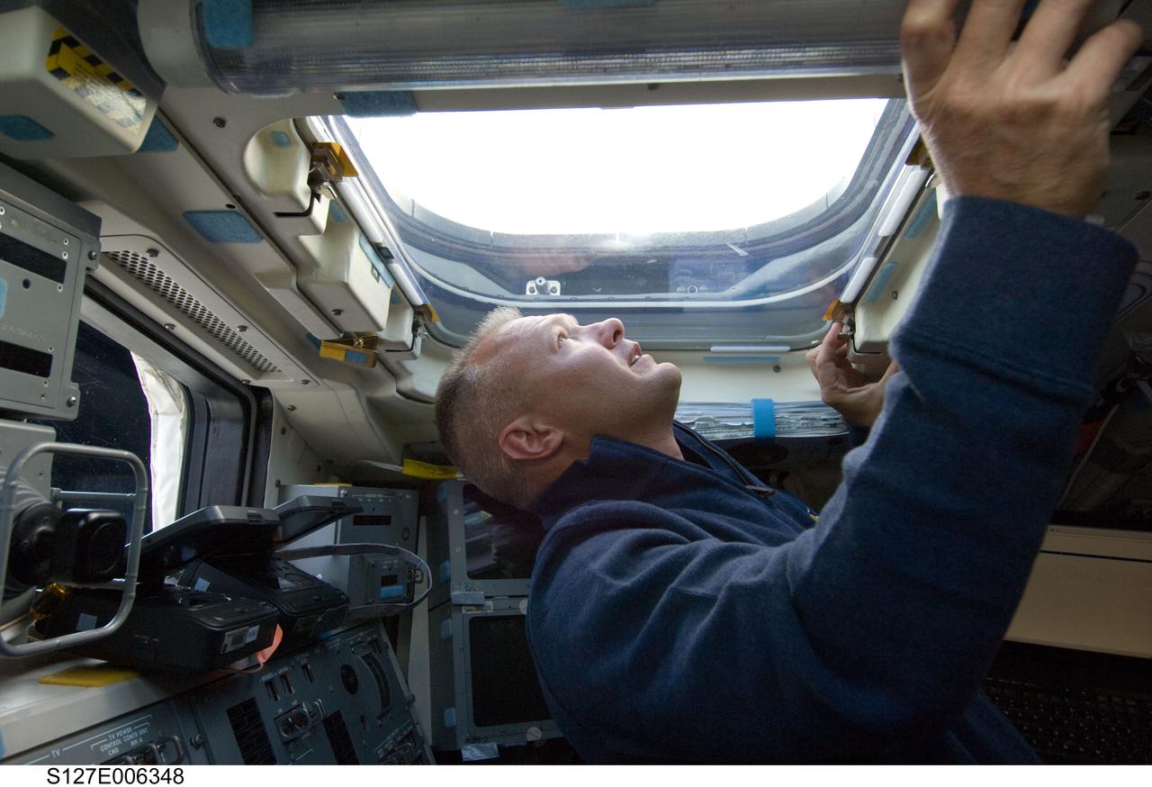 S127-E-006348 (16 July 2009) --- Astronaut Doug Hurley, STS-127 pilot, looks through an overhead window on the aft flight deck of Space Shuttle Endeavour during flight day two activities.
