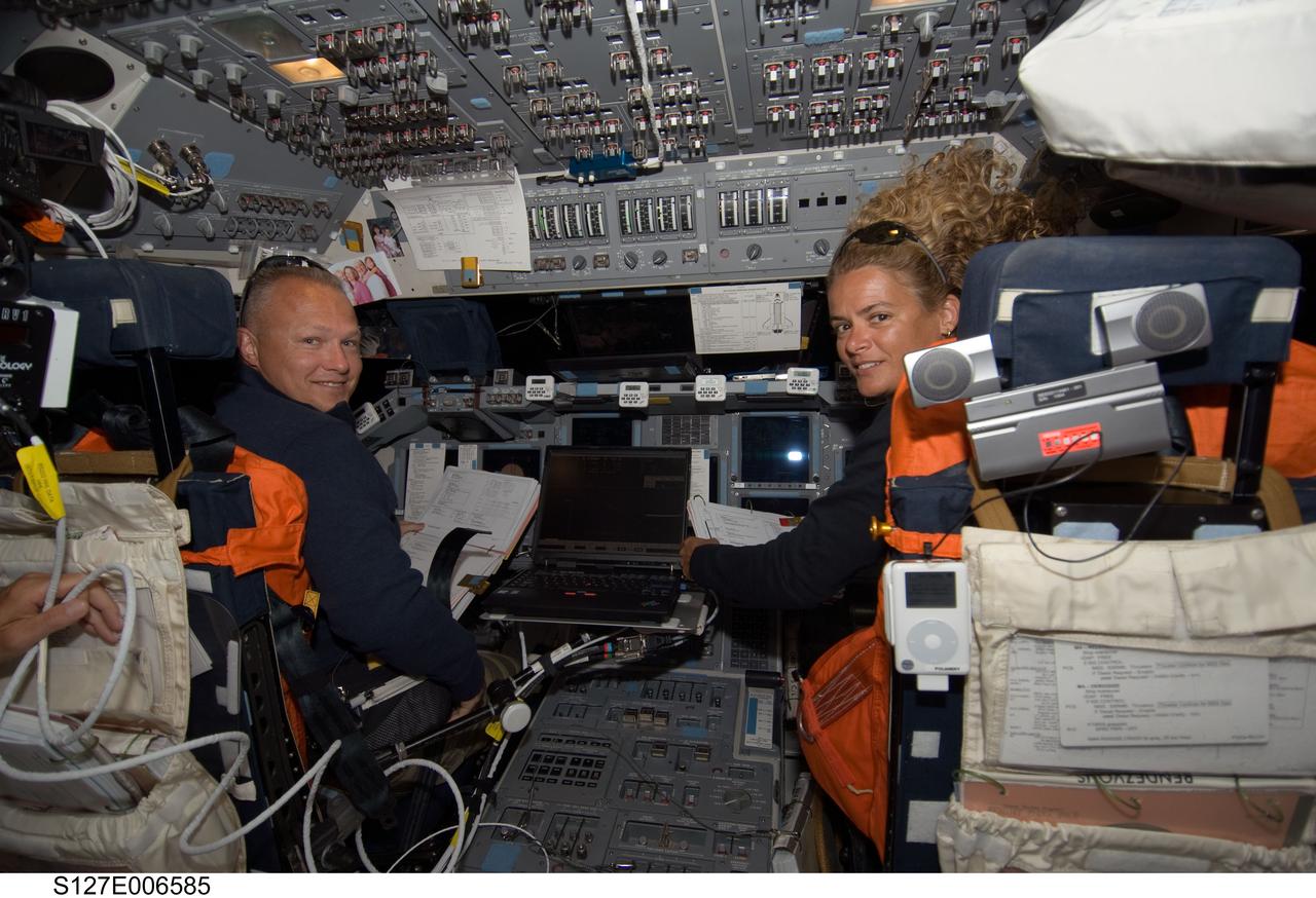 S127-E-006585 (17 July 2009) --- Astronauts Doug Hurley, pilot, and Julie Payette, mission specialist, temporarily switch their attention to a crewmate with a camera while participating in flight day three activities  onboard the Space Shuttle Endeavour.