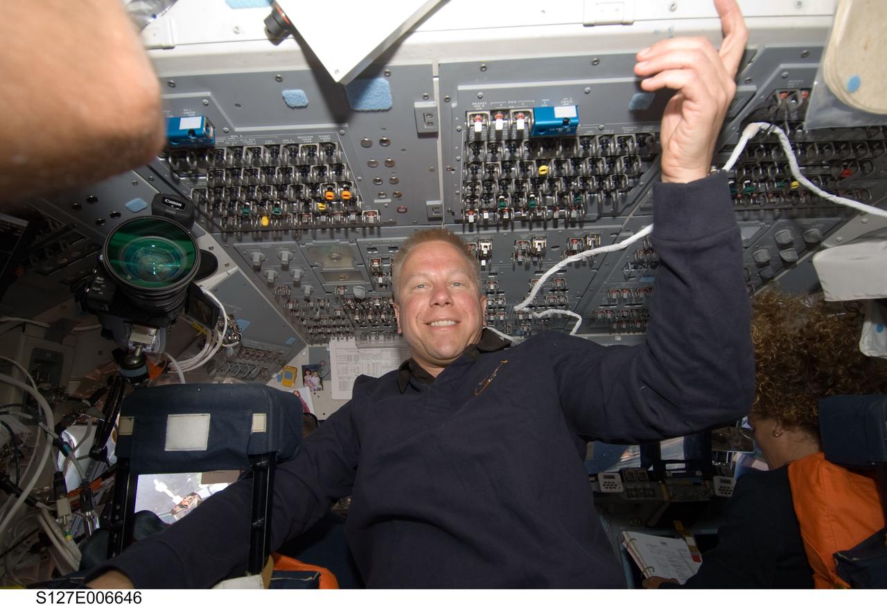 S127-E-006646 (17 July 2009) --- Astronaut Tim Kopra, who will soon be transforming from an STS-127 mission specialist to an Expedition 20 flight engineer, is pictured on Endeavour's flight deck.  The shuttle had not yet docked with International Space Station when this photo was made. Canadian Space Agency astronaut Julie Payette, mission specialist, can be seen at the pilot's station at right.