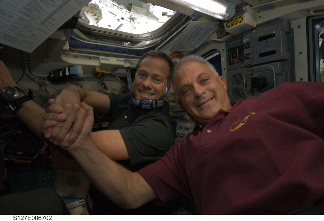 S127-E-006702 (17 July 2009) --- Astronauts Tom Marshburn (left) and Dave Wolf, both STS-127 mission specialists, celebrate the successful docking of the Space Shuttle Endeavour and the International Space Station.