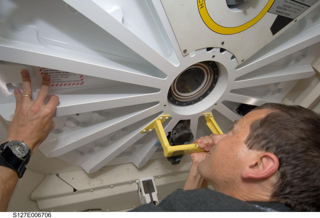 S127-E-006706 (17 July 2009) --- Astronaut Tom Marshburn, STS-127 mission specialist, peers through a window in the hatch that separates seven Endeavour crewmembers from six International Space Station inhabitants. But the separation wasn't for long, as soon afterward the hatch was opened and the visitors from Earth moved onto the station to set the population record at 13. More importantly, over a week's worth of joint activities lies ahead for the two crews.