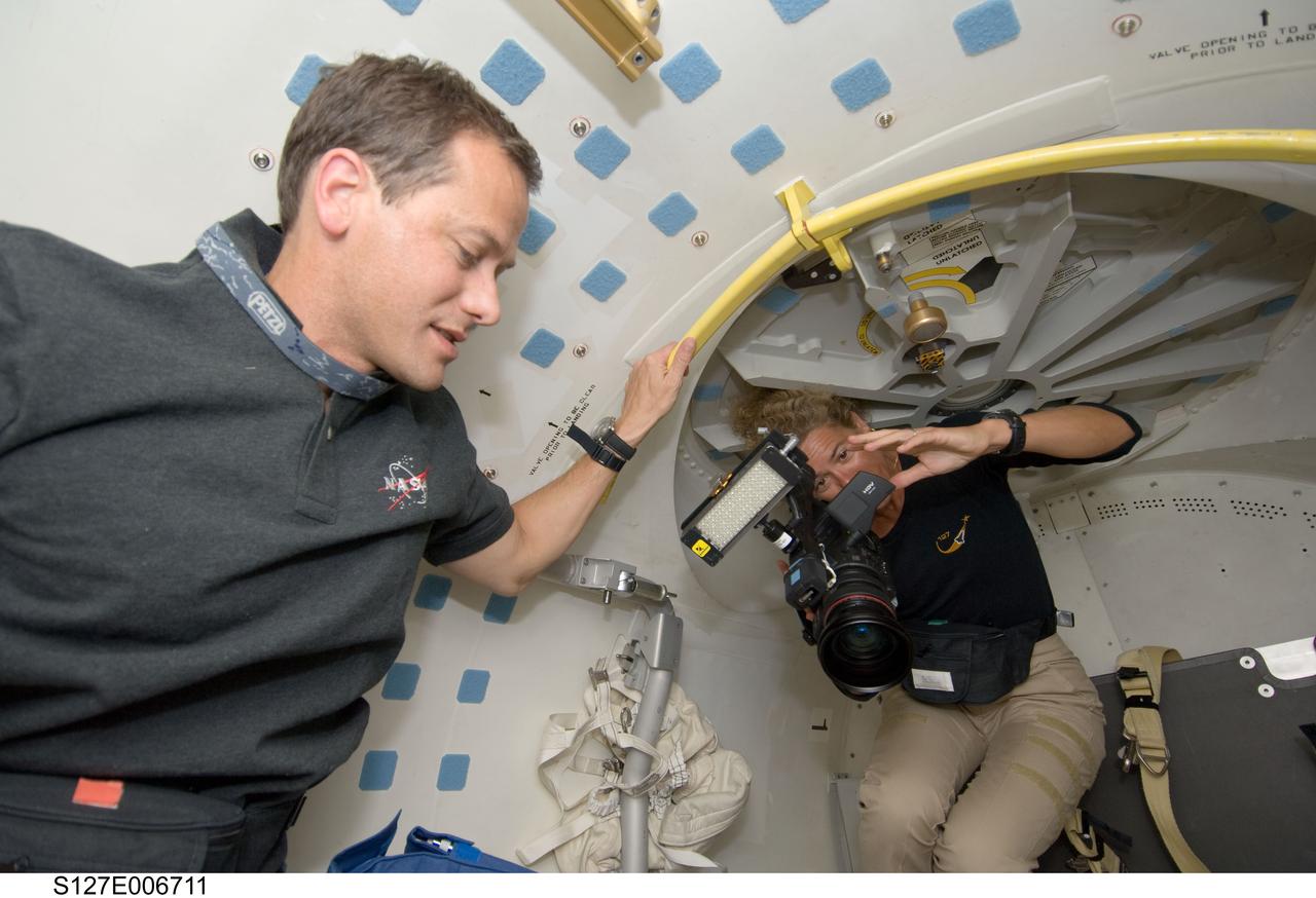 S127-E-006711 (17 July 2009) --- Hatch opening means camera time. That's why Canadian Space Agency astronaut Julie Payette, STS-127 mission specialist, readies her camera for the impending reunion between the Endeavour crew and its hosts onboard the International Space Station. Astronaut Tom Marshburn, STS-127 mission specialist, also awaits the reunion and subsequent joint activities.