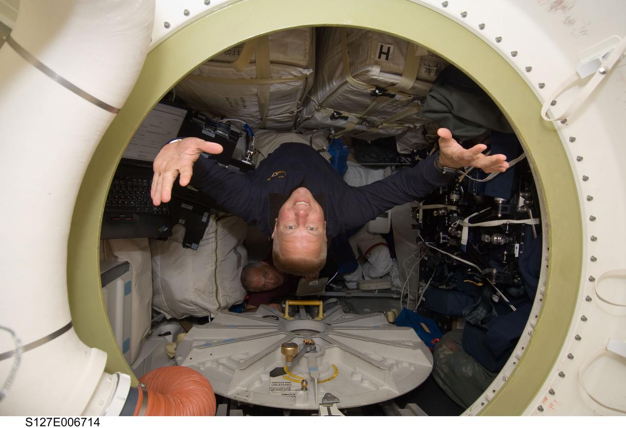 S127-E-006714 (17 July 2009) --- Astronaut Tim Kopra, STS-127 mission specialist, floats toward his new home for the next several months, as he will soon transform from a shuttle crewmember to an ISS flight engineer. Astronaut Dave Wolf, STS-127 mission specialist, can be seen in the background. The two are scheduled to join efforts for a July 18 spacewalk.