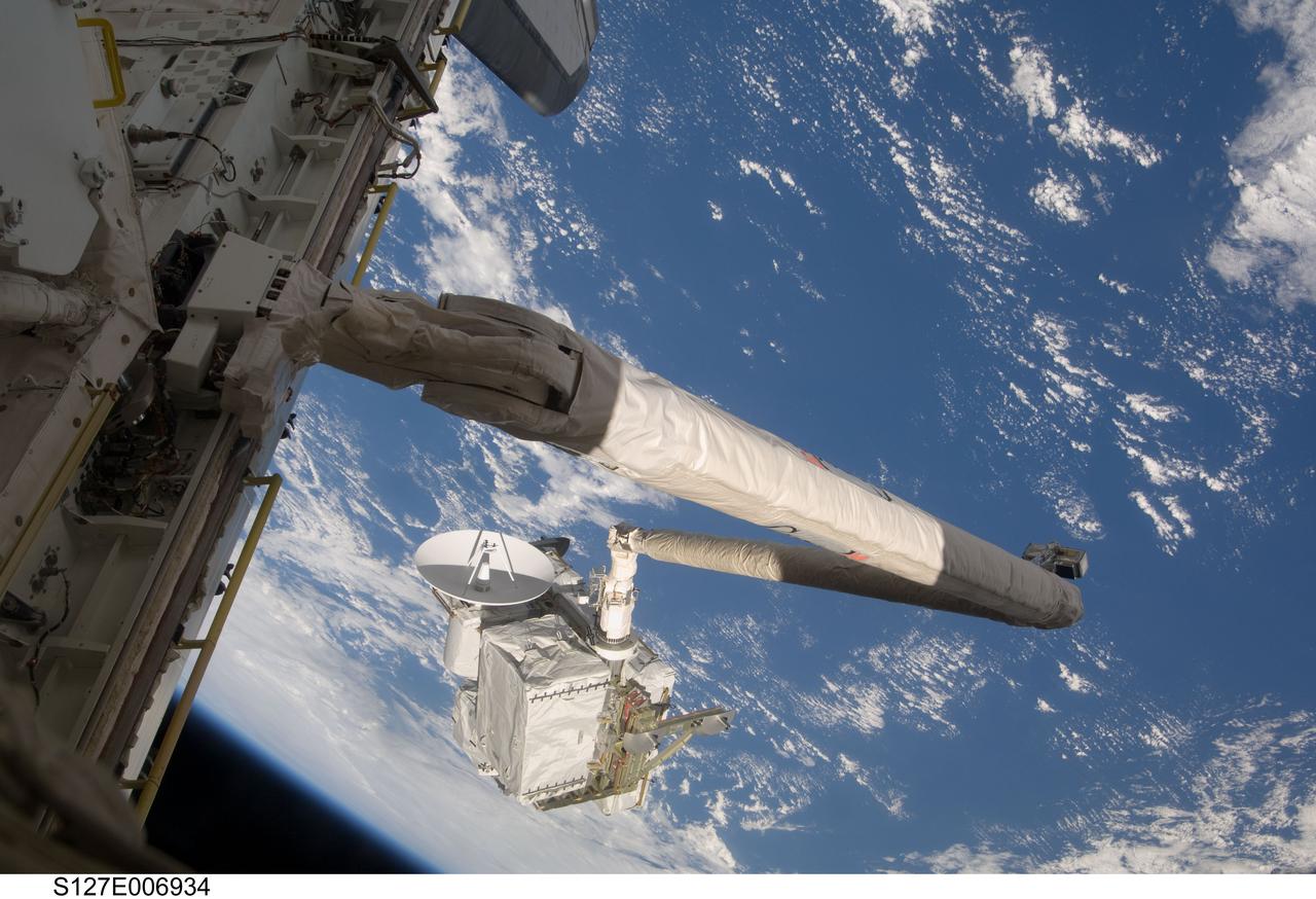 S127-E-006934 (19 July 2009) --- Backdropped by a blue and white Earth, the remote manipulator system (RMS) arm of the Space Shuttle Endeavour, is about to hand off the Integrated Cargo Carrier (ICC) to the International Space Station (out of frame). The ICC is an unpressurized flat bed pallet and keel yoke assembly that was carried into space in the shuttle's payload bay.