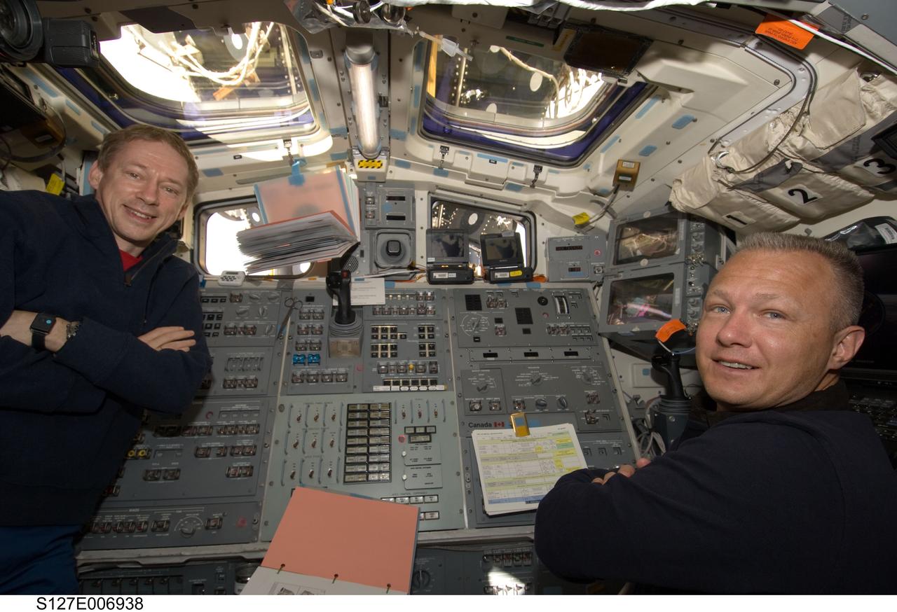 S127-E-006938 (19 July 2009) --- European Space Agency astronaut Frank De Winne (left), Expedition 20 flight engineer, and Doug Hurley, STS-127 pilot, are pictured at Endeavour's aft flight deck controls during flight day five operations with hardware on the International Space Station. The hardware moves conducted by astronauts Mark Polansky (out of frame), commander, and Hurley, in tandem with crew members onboard the station, will enable the second pair of spacewalkers--mission specialists Dave Wolf and Tom Marshburn--to perform its spacewalk assignment on July 20.