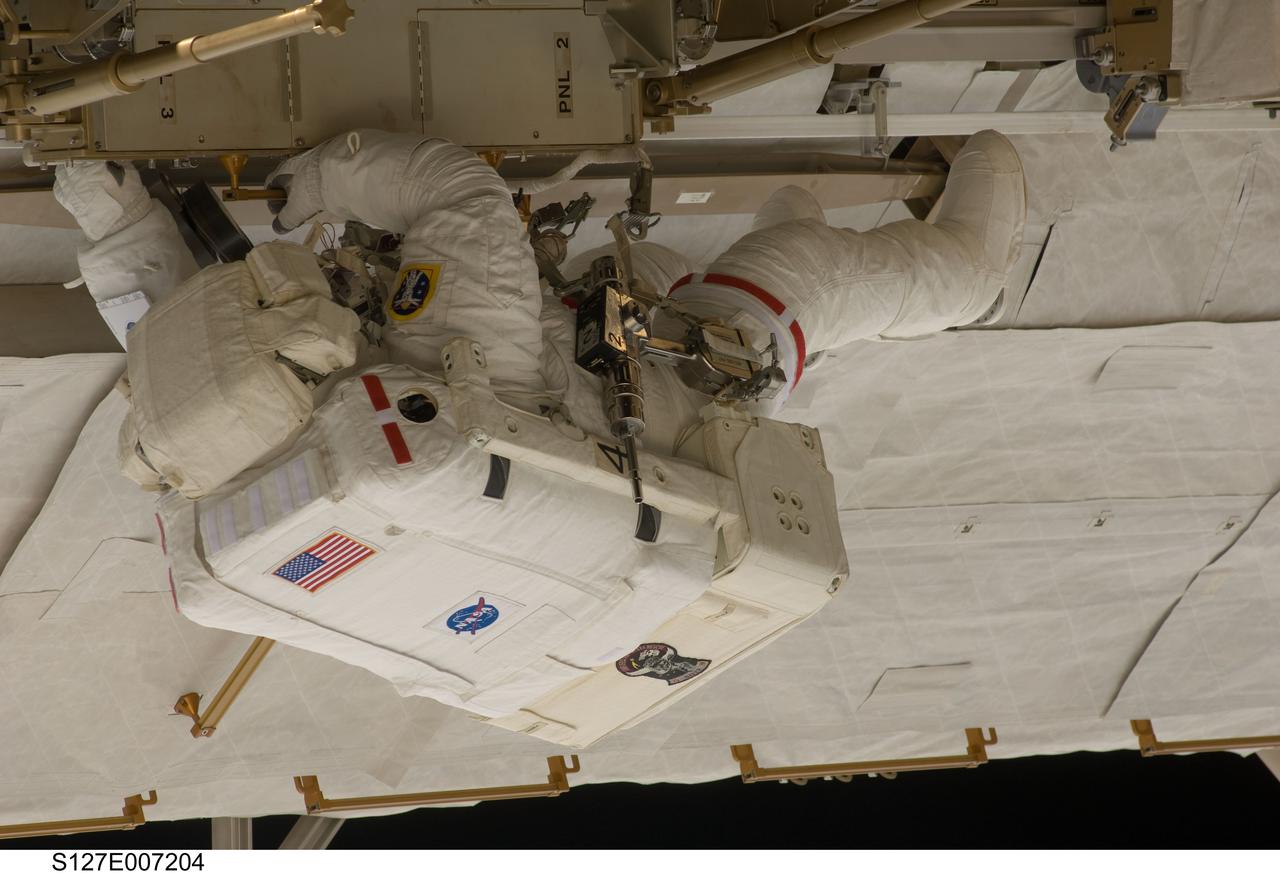 S127-E-007204 (20 July 2009) --- This is one of a series of digital still images showing astronaut Tom Marshburn  performing his first spacewalk and the Endeavour crew’s second of the scheduled five overall in a little more than a week to continue work on the International Space Station.   Astronauts Marshburn and Dave Wolf  (out of frame), both mission specialists,  successfully transferred a spare KU-band antenna to long-term storage on the space station, along with a backup coolant system pump module and a spare drive motor for the station's robot arm transporter. Installation of a television camera on the Japanese Exposed Facility experiment platform was deferred to a later spacewalk.