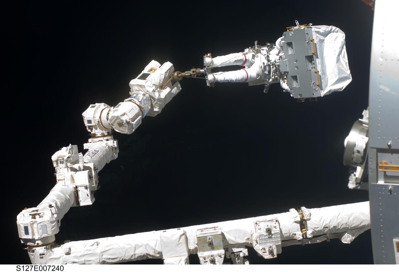 S127-E-007240 (20 July 2009) --- During the second STS-127 spacewalk, astronauts Dave Wolf and Tom Marshburn (out of frame), with help from their crewmates inside the International Space Station and the Space Shuttle Endeavour, transported the Linear Drive Unit (LDU) and two other parts to the station's External Stowage Platform 3 for long-term storage. Wolf is standing on the end of Canadarm2, which is anchored on the orbital outpost.