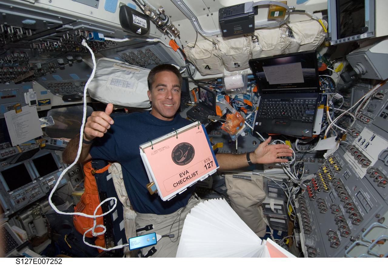 S127-E-007252 (20 July 2009) --- Astronaut Christopher Cassidy, STS-127 mission specialist, watches a checklist for extravehicular activity float in front of him on Endeavour's flight deck. Cassidy was inside the cabin supporting the spacewalk of two crewmates on July 20, but he just may have been anticipating his own first spacewalk in two days.