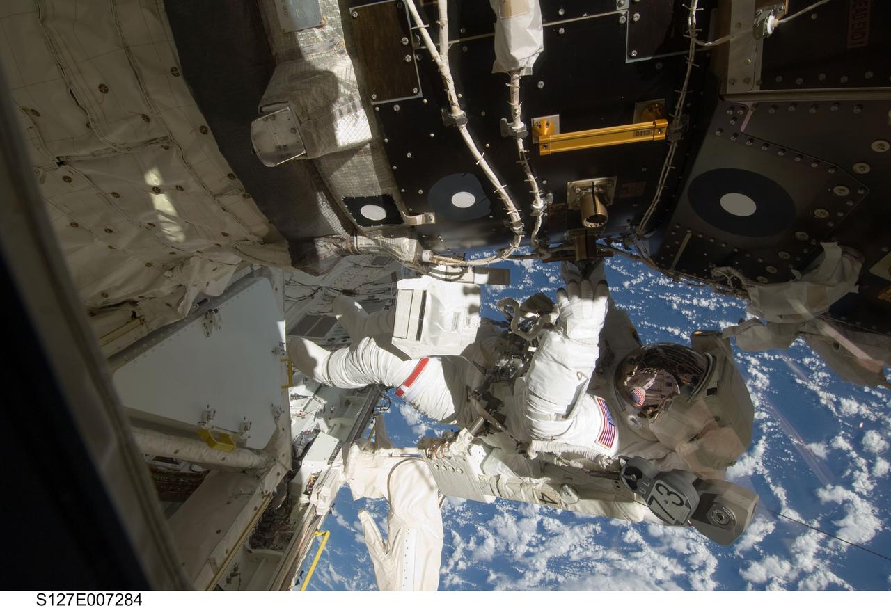 S127-E-007284 (20 July 2009) --- This is one of a series of digital still images showing astronaut Tom Marshburn  performing his first spacewalk and the Endeavour crew’s second of the scheduled five overall in a little more than a week to continue work on the International Space Station.   Astronauts Marshburn and Dave Wolf  (out of frame), both mission specialists,  successfully transferred a spare KU-band antenna to long-term storage on the space station, along with a backup coolant system pump module and a spare drive motor for the station's robot arm transporter. Installation of a television camera on the Japanese Exposed Facility experiment platform was deferred to a later spacewalk.