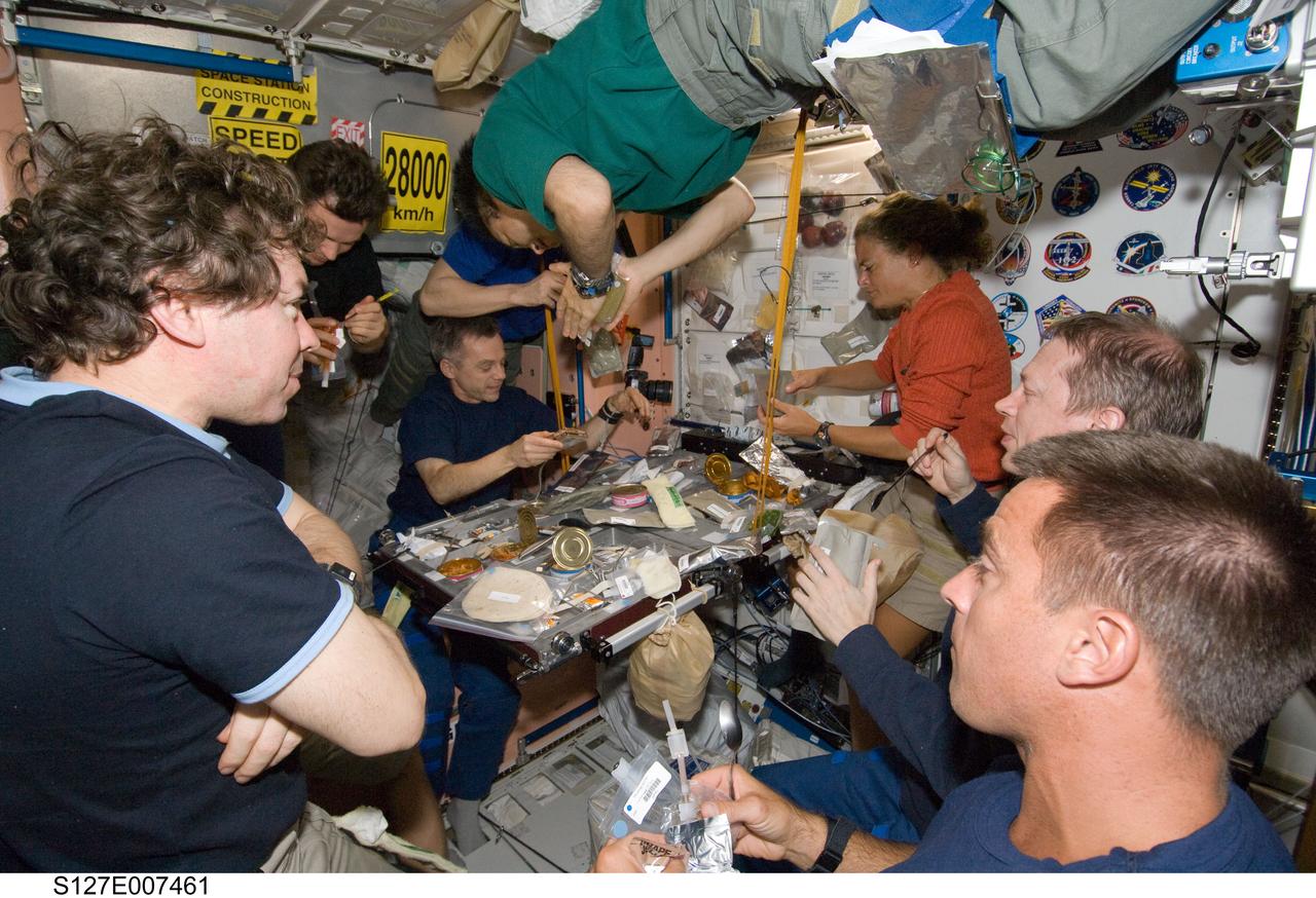 S127-E-007461 (21 July 2009) --- Eight of a total aggregation of 13 astronauts and cosmonauts are pictured at meal time aboard the International Space Station. Pictured, clockwise from bottom right, are astronauts Christopher Cassidy and Mike Barratt, with Russian Federal Space Agency cosmonaut Roman Romanenko, an unidentified crew member, Japanese Aerospace Exploration Agency astronaut Koichi Wakata (floating above), Canadian Space Agency astronauts Robert Thirsk and Julie Payette, European Space Agency astronaut Frank De Winne, and astronaut Christopher Cassidy. Either out of frame or not clearly seen are astronauts Mark Polansky, Doug Hurley, Dave Wolf, Tim Kopra and Tom Marshburn, plus Russian Federal Space Agency cosmonaut Gennady Padalka. Seven astronauts left Kennedy Space Center one week ago aboard the Space Shuttle Endeavour to join up with the six Expedition 20 crew members on the orbital outpost to continue work on it. The space fliers have completed two of five scheduled spacewalks up to this point.
