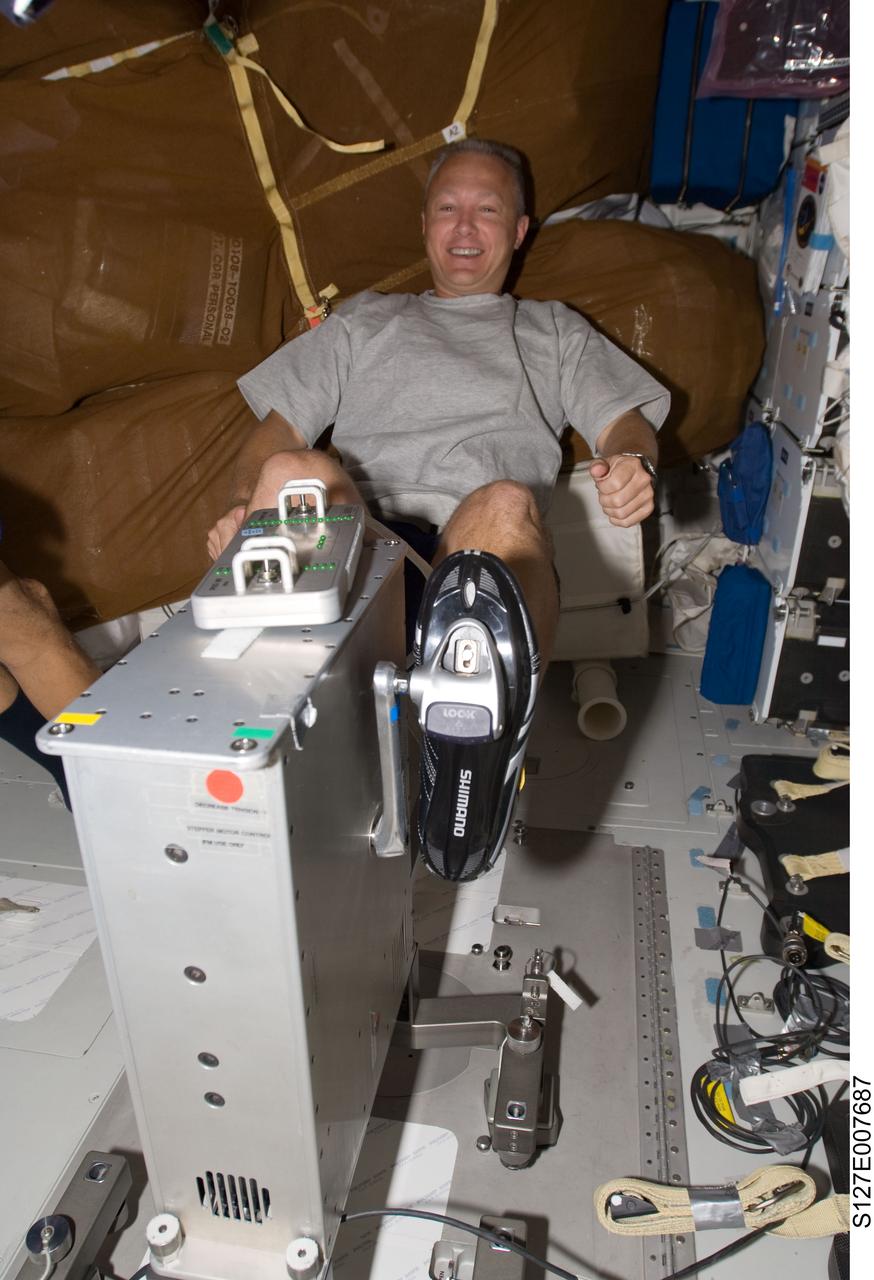 S127-E-007687 (22 July 2009) --- Astronaut Doug Hurley, STS-127 pilot, works out on the bicycle ergometer on Endeavour's mid deck during flight day 8 activities.