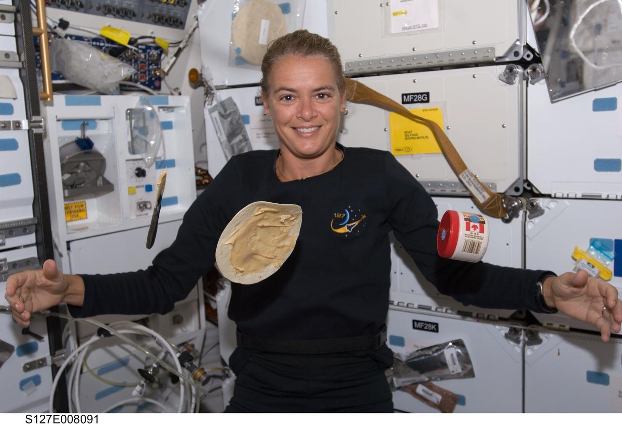 S127-E-008091 (23 July 2009) --- Canadian Space Agency astronaut Julie Payette, STS-127 mission specialist, watches as a tortilla floats in front of her on Endeavour's middeck during flight day nine.