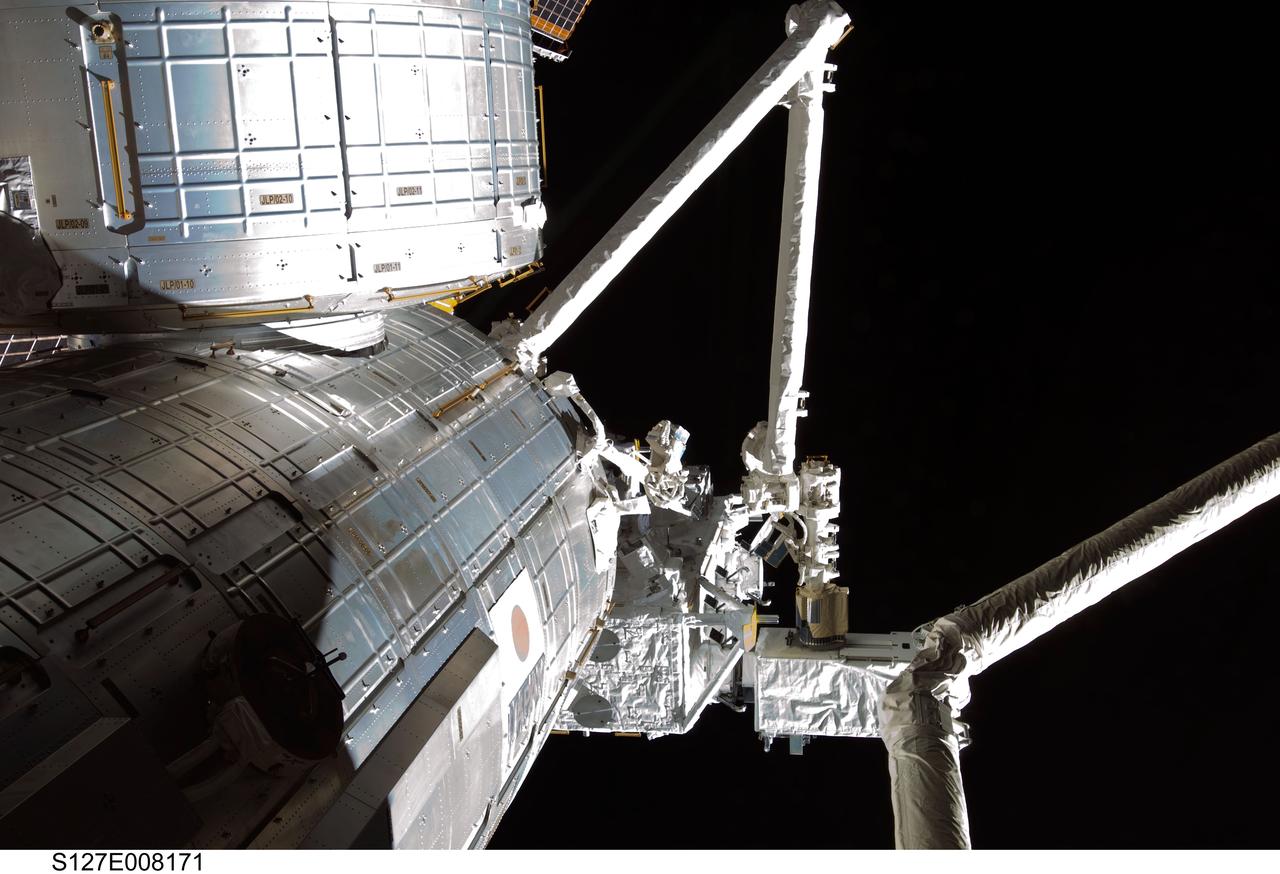 S127-E-008171 (23 July 2009)--- The robotic arm of the Japanese Experiment Module or Kibo assists in the installation of MAXI payload on the Japanese Exposed Facility (JEF) on flight day 9.