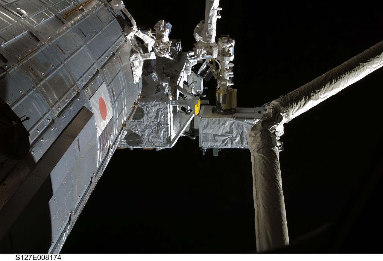 S127-E-008174 (23 July 2009)--- The robotic arm of the Japanese Experiment Module or Kibo assists in the installation of MAXI payload on the Japanese Exposed Facility (JEF) on flight day 9.